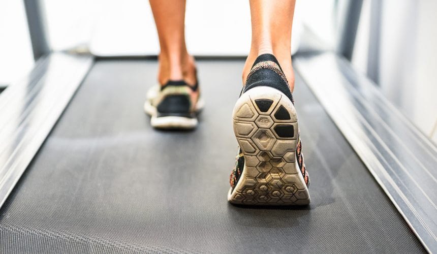 Male muscular feet in sneakers running on the treadmill at the gym. Concept for fitness, exercising and healthy lifestyle.